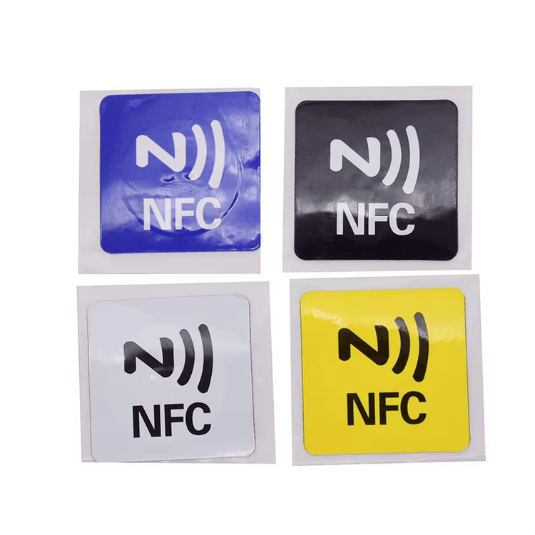 أربعة وسوم RFID مربعة من PVC مخصصة للأسطح المعدنية باللون الأزرق والأسود والأبيض والأصفر، تحمل شعار NFC وتُظهر خيارات الألوان القابلة للطباعة لملصقات المعدات.