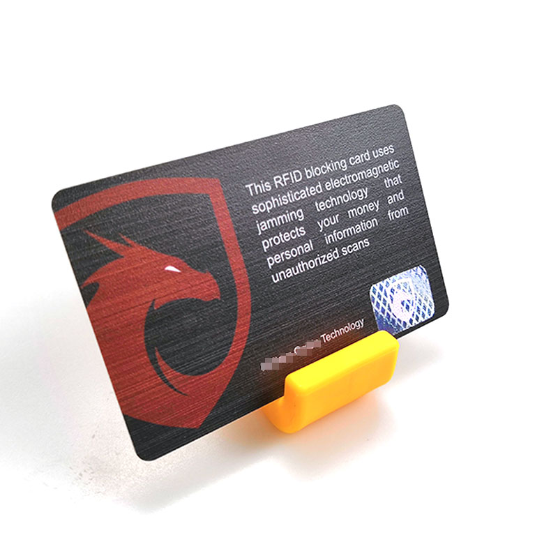 صورة قريبة لبطاقة حجب RFID على حامل أصفر تعرض رمز الدرع الأحمر وعبارة مكافحة المسح لأمان السفر.