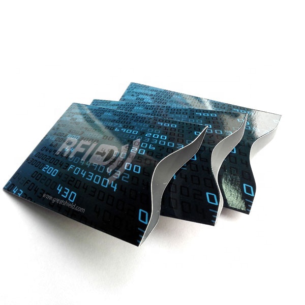 أغلفة RFID بنمط أزرق ثنائي مرتبة بشكل مروحي لإظهار شكل حافظة بطاقة لامعة مع فتحة إخراج منحنية.