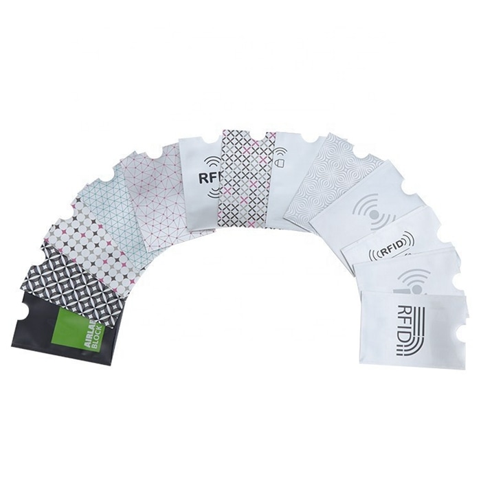 مجموعة عينات مرتبة كالمروحة تعرض أغلفة عديدة مطبوعة لحجب RFID تشمل تصاميم شعارات ونقوشًا هندسية للاستئناس بها في إعداد الرسومات المخصصة.