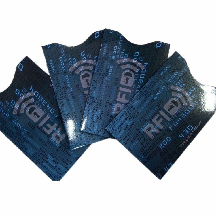 أربعة أغلفة زرقاء لحجب RFID بتصميم GreatShield مرتبة كالمروحة لإظهار نقشة الرموز اللامعة وفتحة الإبهام المنحنية.
