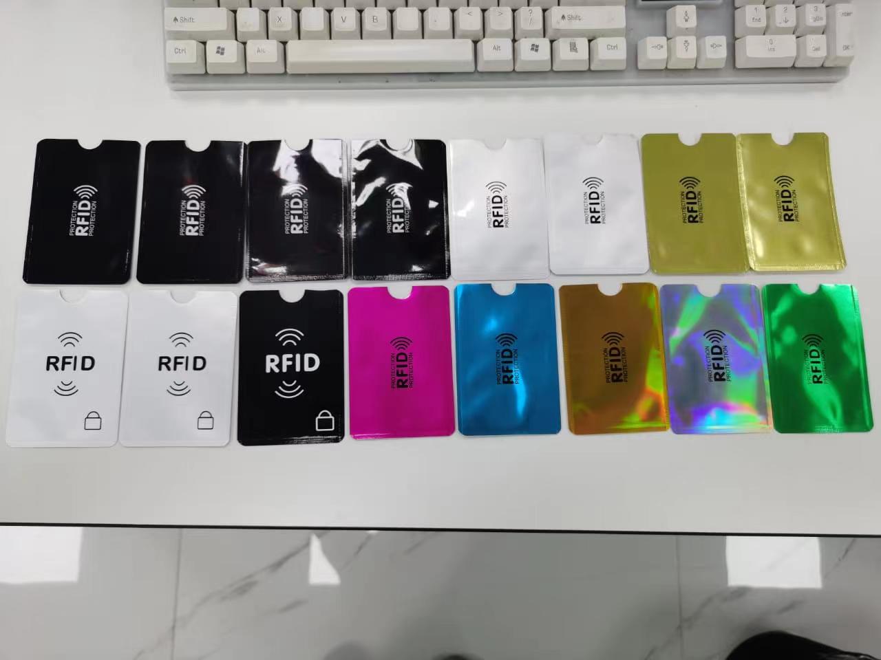 مجموعة من أغلفة RFID المانعة للقراءة مرتبة في صفوف أسفل لوحة مفاتيح للمقارنة بين الأسطح اللامعة والمطفأة والمعدنية.