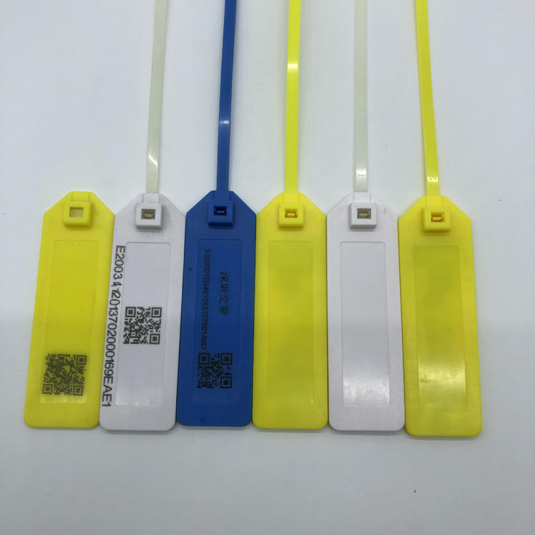 يعرض صف من وسوم ربط كابلات RFID عينات للحفر بالليزر تتضمن رمز QR ونصًا ثابتًا ولوحات فارغة على وسوم صفراء وبيضاء وزرقاء.
