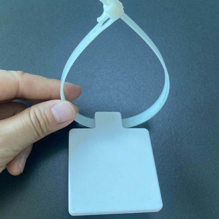 يد تمسك وسم RFID برباط كابلات Z5555-1 لإظهار حلقة النايلون المرنة واللوحة المربعة الفارغة الجاهزة للطباعة.