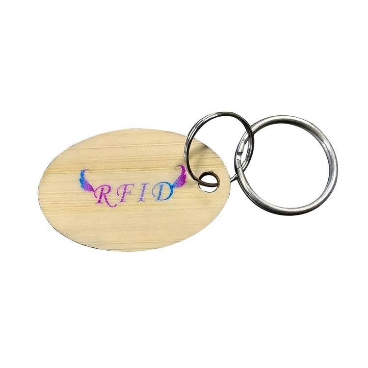 تحمل ميدالية مفاتيح RFID خشبية بيضاوية بمقاس 36x29.5mm شعار RFID ملونًا، وهي مثبتة بحلقة مفاتيح مشقوقة.