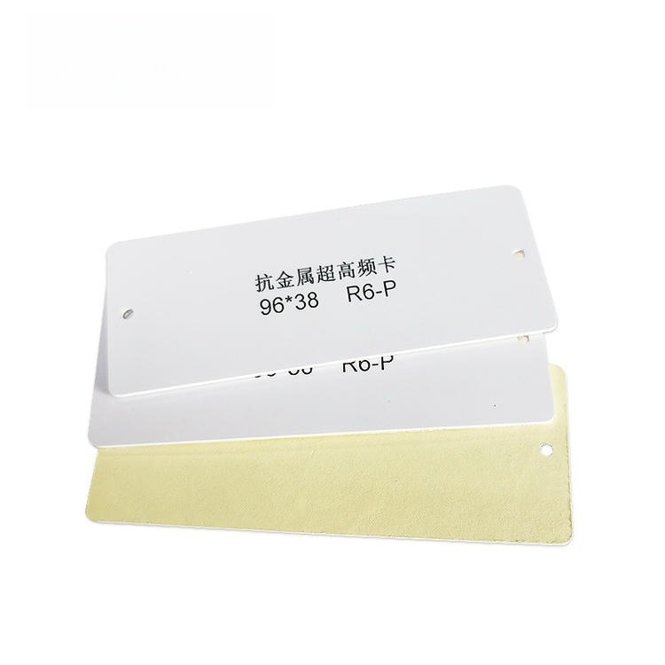 عينة من وسم RFID معدني من PVC بعلامة R6-P، بواجهة بيضاء قابلة للطباعة وظهر ذهبي عازل لتتبع أصول UHF بعيد المدى.