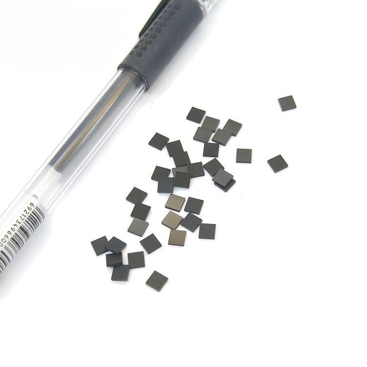 منظر علوي لعلامات SV-001 micro RFID POD متناثرة قرب قلم يوضح العلامات المربعة الصغيرة للتتبع UHF في المواقع القاسية.
