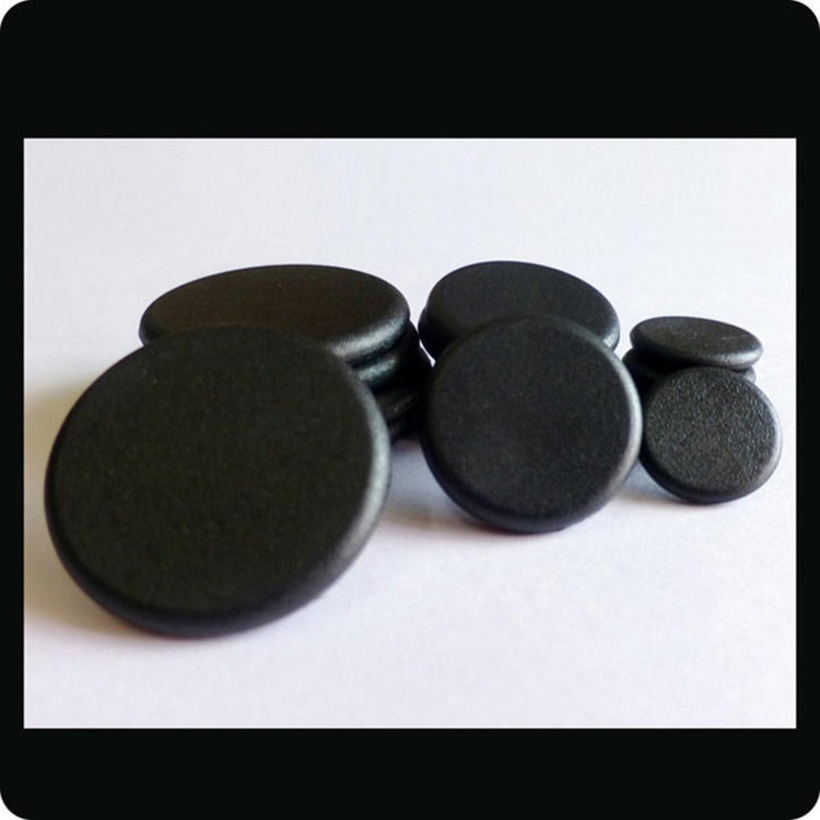 لقطة قريبة لعدة أقراص سوداء من علامات RFID من PPS توضح الشكل الصلب الشبيه بالعملة للطراز PPSD28-1 في البيئات الصناعية القاسية.