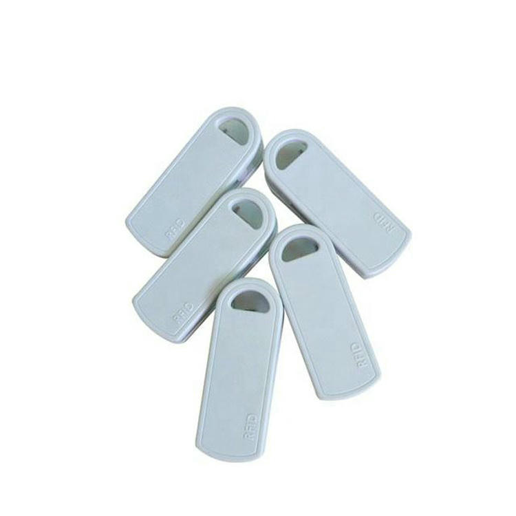 تعرض هذه الصورة خمسة وسوم RFID بيضاء بمشبك SV-014 مرتبة كمروحة لإظهار الشكل الأمامي وفتحة الشق.