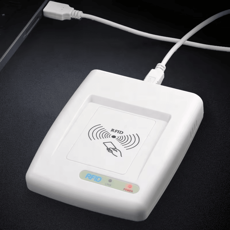 تُظهر هذه الصورة قارئ HF RFID طراز RC200U متصلًا بكابل USB على مكتب لإظهار التشغيل بالطاقة واتصال البيانات.