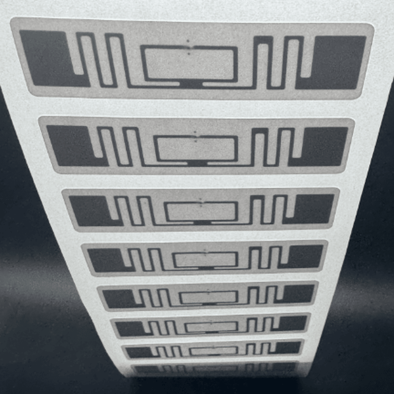 صورة مقربة لشريط من بطانات ملصقات UHF RFID بمقاس 70x15mm جاهزة للتشفير والفرز اللوجستي عالي الإنتاجية.