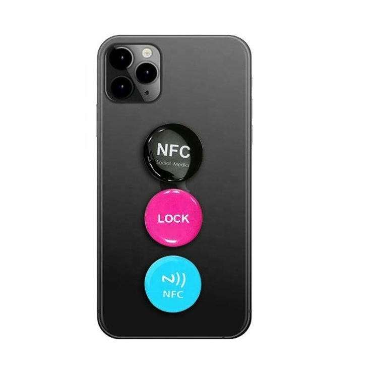 ملصقات NFC إيبوكسية مستديرة موضوعة على غطاء هاتف توضح نقاط تفاعل تحمل طبقة إضافية بسيطة للهوية التجارية لتنفيذ إجراءات باللمس واختصارات سريعة.